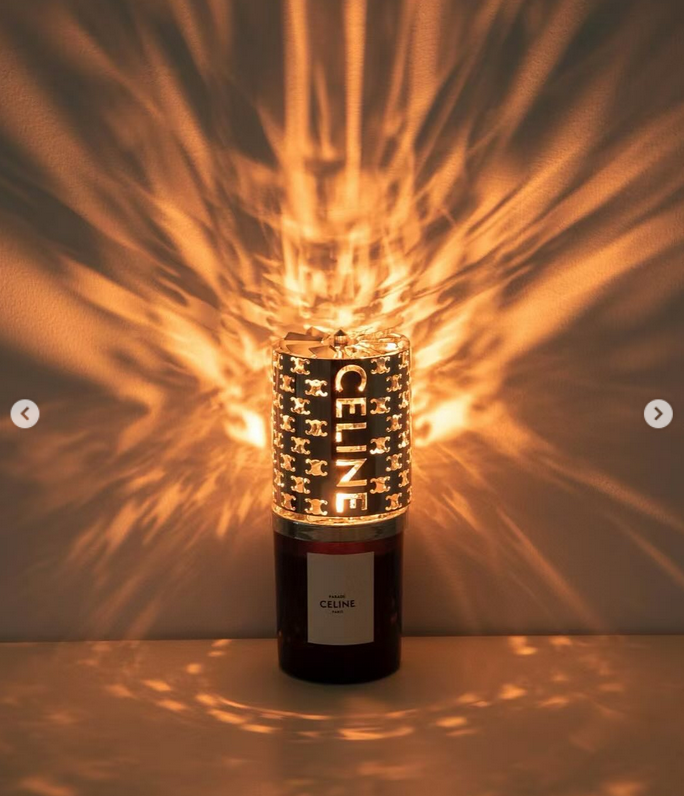 Celine Haute Parfumerie Silence Blanc scented candle gift set. The set features a 240g perfumed candle housed in a black glass container with a black wax wick. It includes a metallic cut-out candle holder designed to mimic the lines of a Celine perfume bo - Image 3 of 3